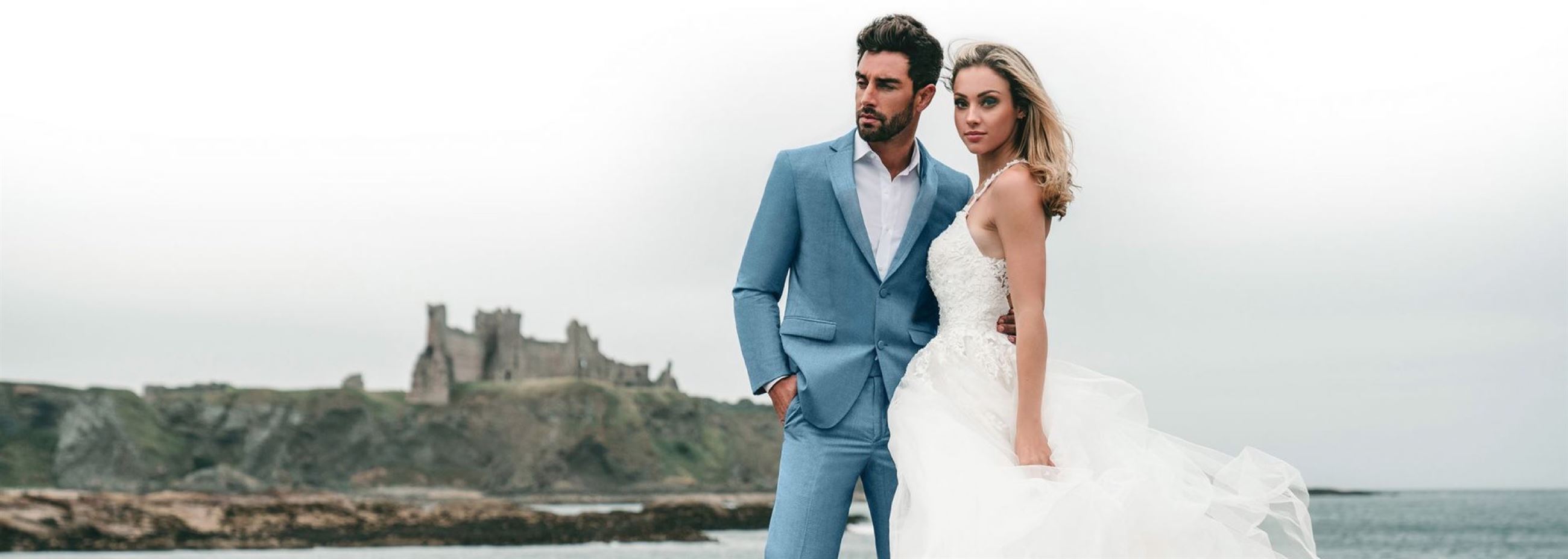 Groom in baby blue tuxedo and bride in flowy wedding gown next to each other